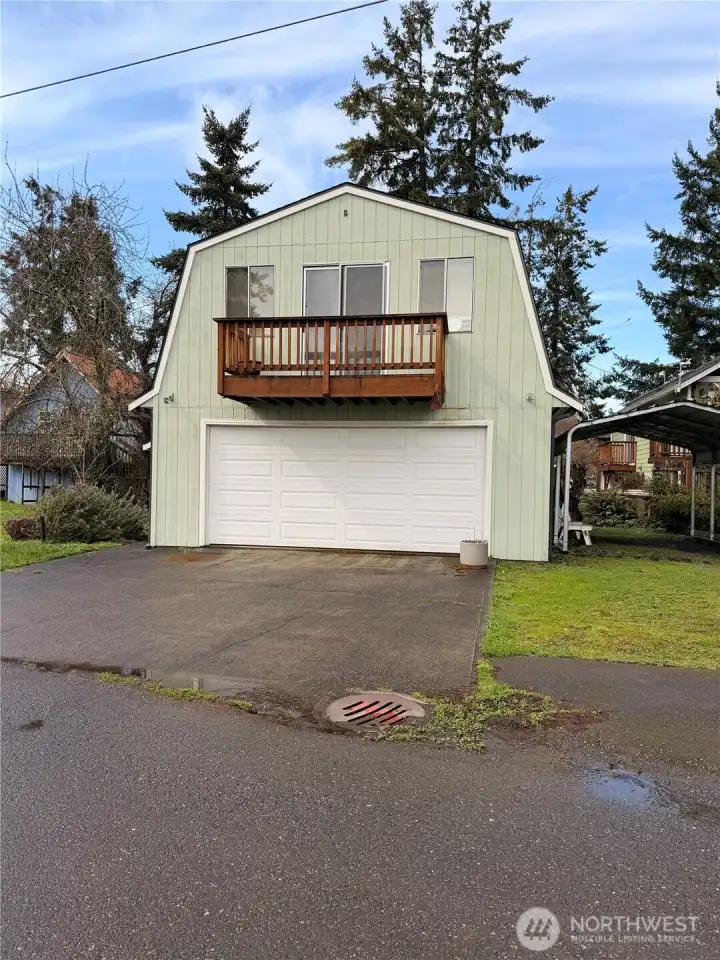 Detached two story garage with storage space and side yard carport.