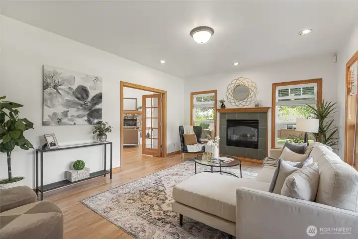 Spacious living room with hardwood floors, abundant natural light, and a cozy fireplace creating the perfect space to relax or entertain.