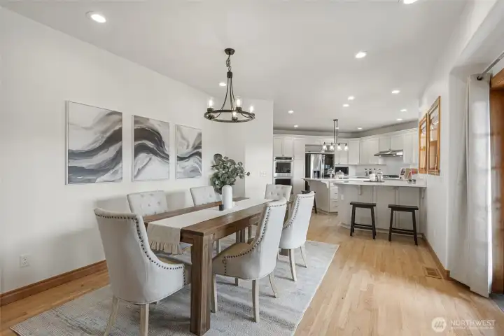 Spacious dining area flows seamlessly into the beautifully updated kitchen, featuring hardwood floors, abundant natural light, and an open design ideal for everyday living and entertaining.