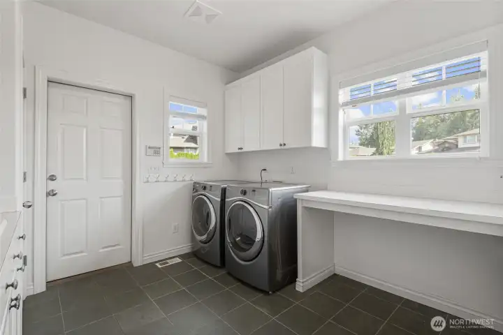 Spacious utility room with abundant storage, folding counter, and natural light adds everyday convenience to this private estate-style retreat designed for comfortable Northwest living.