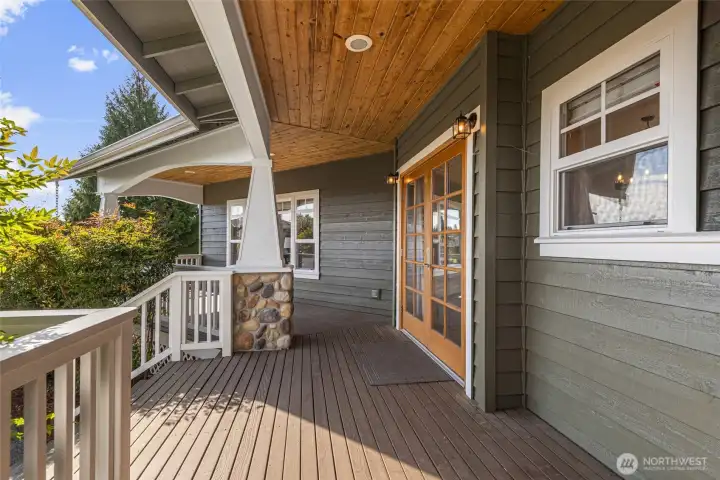 French doors open to an expansive covered deck and patio, creating the perfect setting for outdoor living, entertaining, and enjoying the home’s peaceful private surroundings.