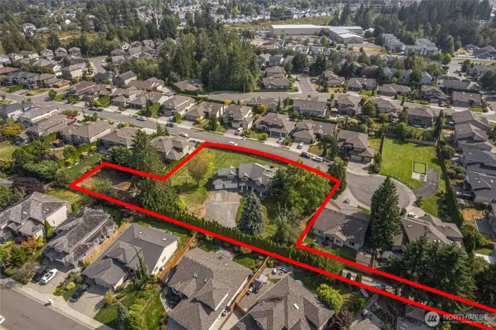 Drone view highlights the impressive 1.21-acre lot outlined in red, showcasing the property’s rare usable space, privacy, and estate-like setting near Mill Creek.