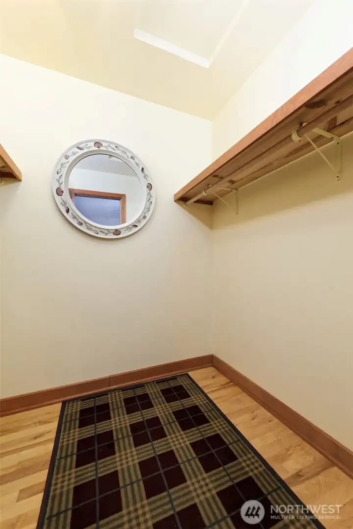 walk in closet with Shell rimmed mirror.