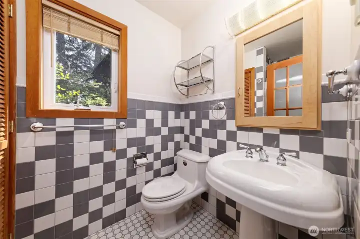 spotless tiled bathroom with large pedestal sink and medicine cabinet.