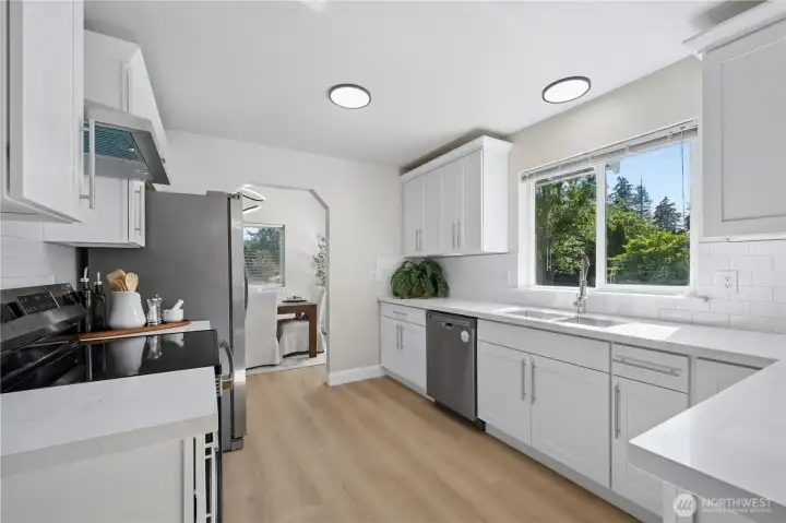 The kitchen showcases quartz countertops, tile backsplash, new cabinetry, stainless steel appliances and a timeless subway tile backsplash.