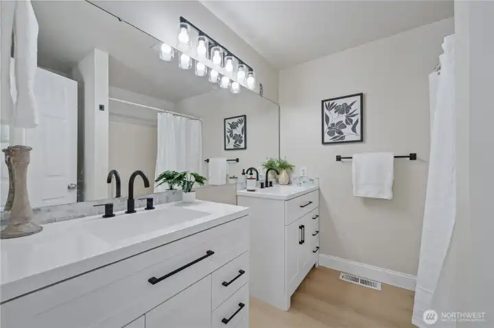 The remodeled primary bath features brand new dual vanities, hardware, lighting, fixtures and flooring.