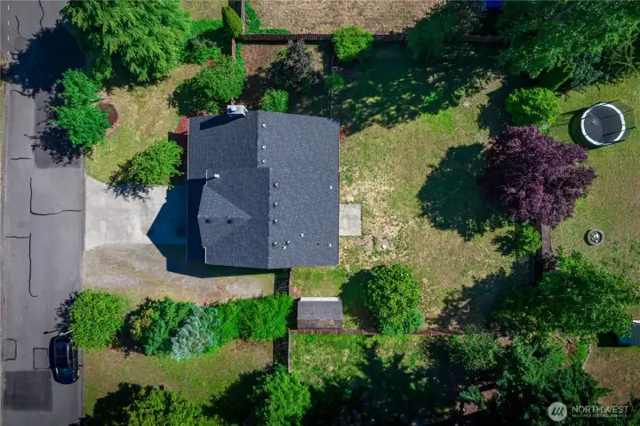 An aerial view showcases this level, lovely lot and its peaceful setting. You can see the ample gravel RV or boat parking on the right side of the property.