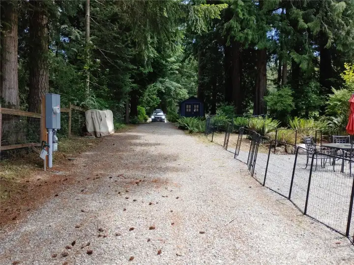 View down driveway without the RV parked in spot. Electric and Water hookups on left of picture.