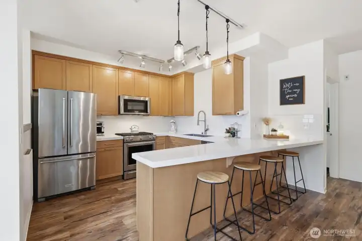 Updated kitchen with eating bar, stainless steel appliances, fresh lighting fixtures