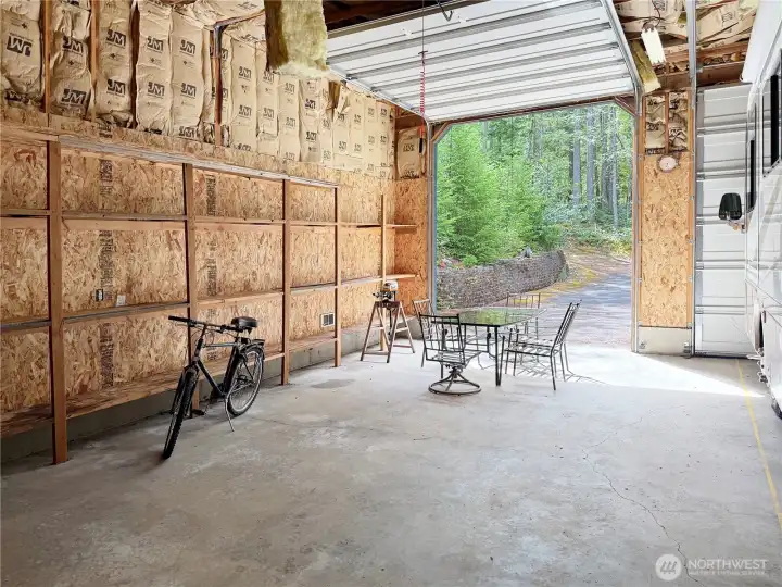 The ultimate hobbyist's dream! This massive, high-clearance shop features soaring ceilings, built-in storage racks, and an oversized bay door designed to accommodate a motorhome, RV, or boat.