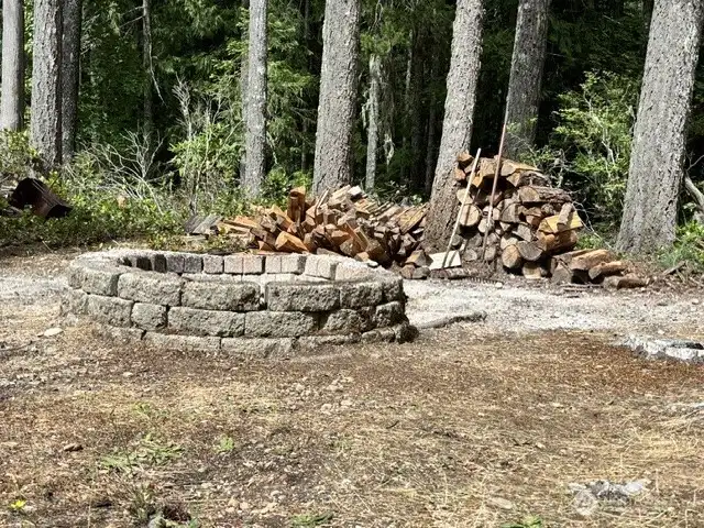 Embrace Pacific Northwest living with your own private, stone-walled backyard fire pit—the ultimate spot for cozy evening gatherings in a peaceful forest setting.