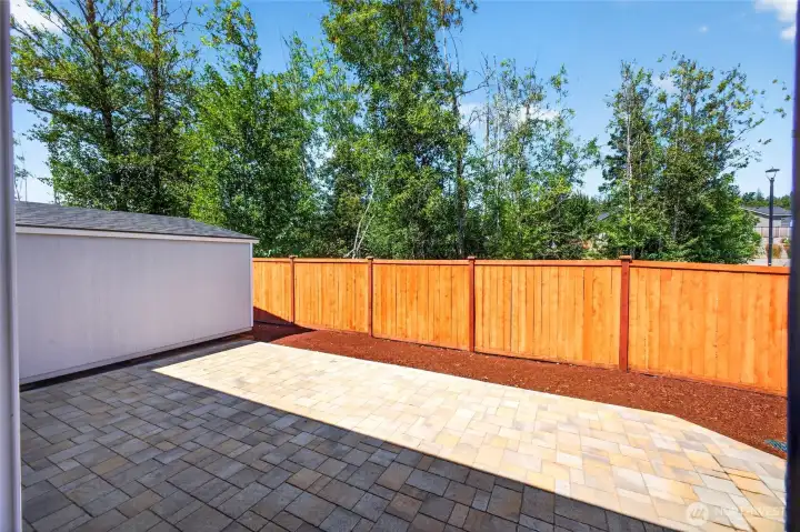 A view of the fenced backyard with custom inlaid stonework, and the shed to the left. Very private! A view of the fenced backyard with custom inlaid stonework, and the shed to the left. Very private!