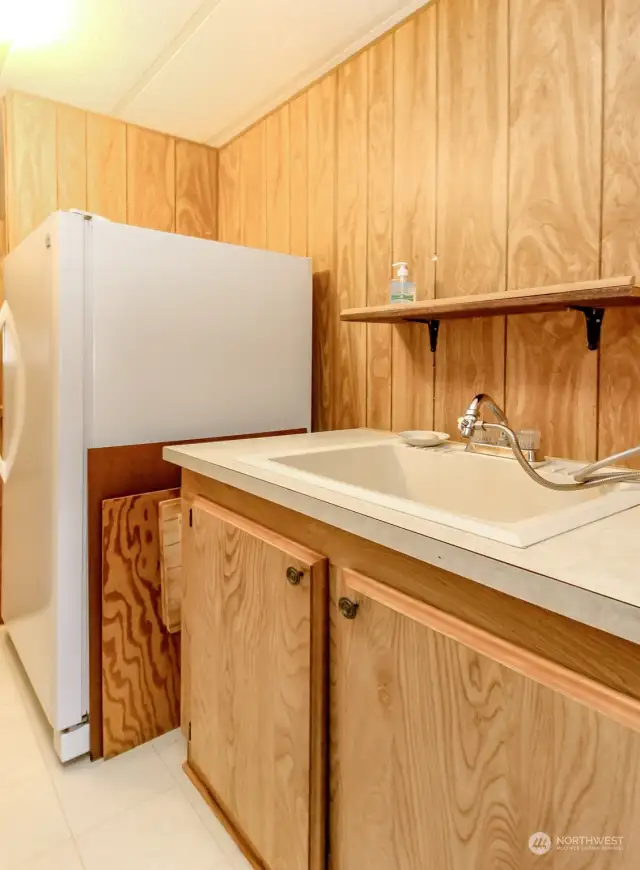 Laundry room has a sink and space for a freezer