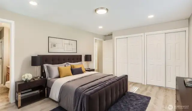 Spacious primary bedroom with two closets and 3/4 bath en suite, virtually staged to show option for residential living.