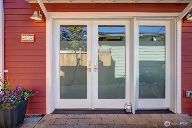Entry doors create an entire  wall of light, just one of many locations where there is seamless connection between indoors and outdoors here.