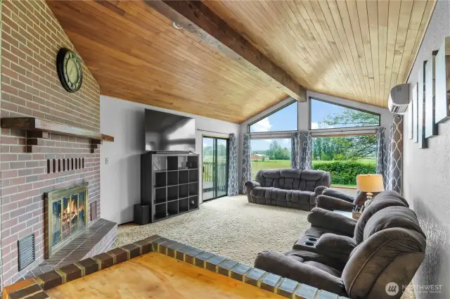 Living room with vaulted ceiling w/center beam and chalet style windows overlooking the beautiful view!