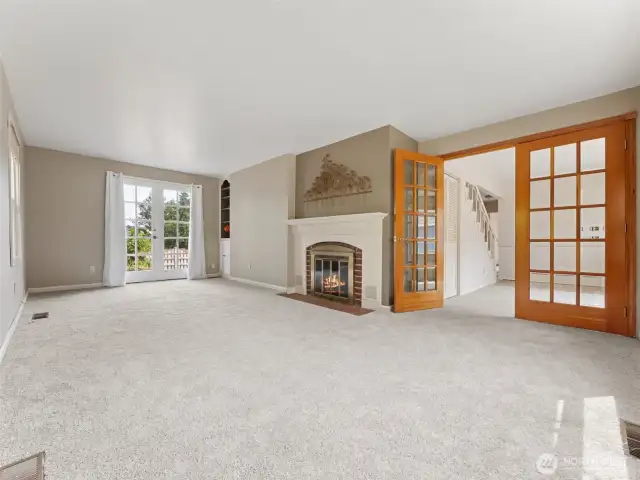 Large living room w/cozy fp and door leading to patio