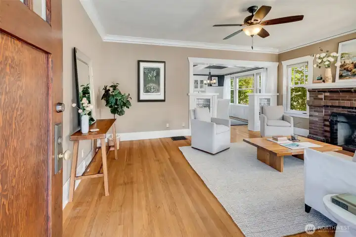 Golden oak hardwood floors throughout the main level, original leaded-glass built-in bookshelves, and a classic brick fireplace that was converted to gas for ease and convenience.