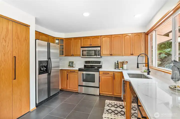 Remodeled kitchen with stunning quartz slab counters, undermount sink and new stainless appliances.