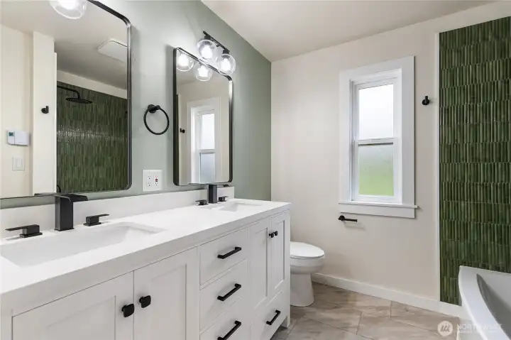 Beautifully appointed bathroom with double shower heads and double sinks. Lots of storage to the left of the sink and in vanity.