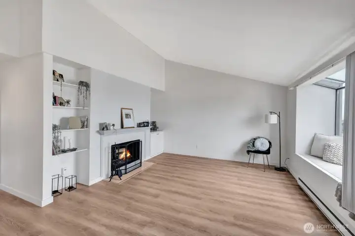 Light and bright living room has vaulted ceiling, fireplace, bay window and nice floors throughout.