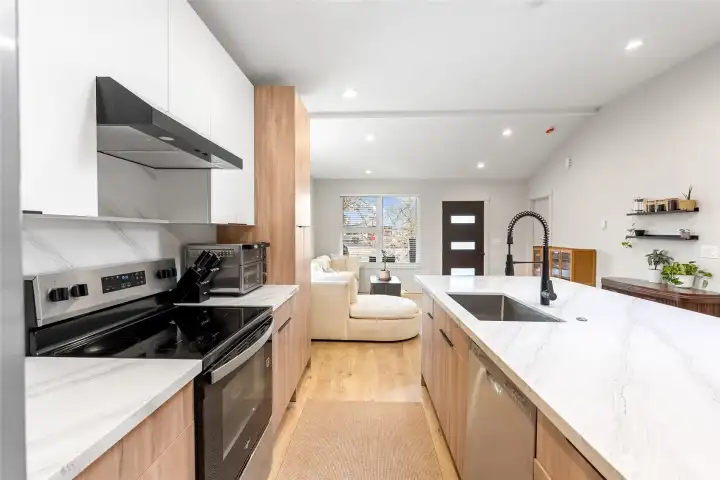 Stylish updated kitchen featuring quartz countertops, modern cabinetry, and a spacious island-perfect for cooking, entertaining, and everyday living.