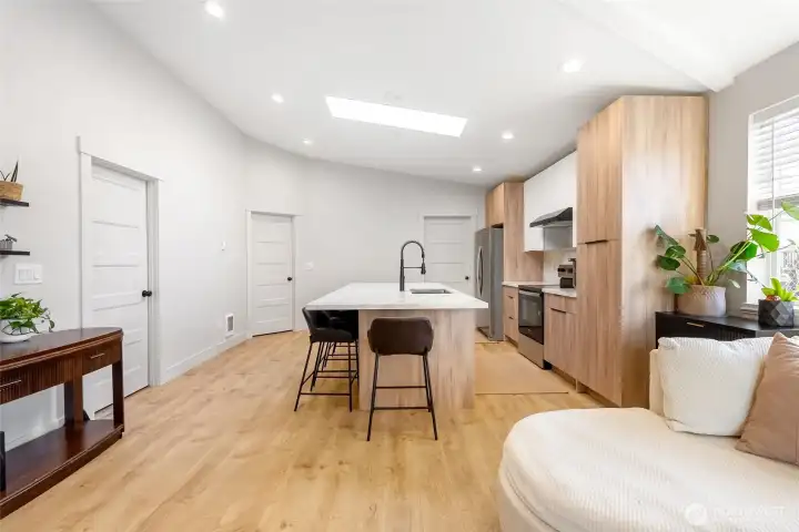 Bright open-concept living with a spacious kitchen and vaulted ceilings.