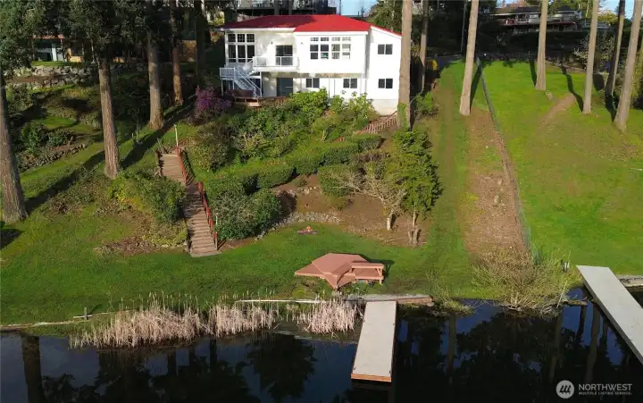 Rare 100' of pristine Lake Meridian waterfront with a private dock & deck at water's edge on one of King County's most desirable lakes