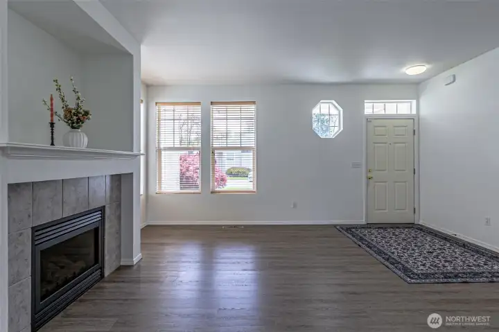 Living room with gas fireplace, luxury vinyl plank flooring throughout home.