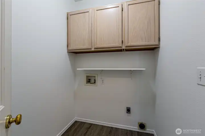 Laundry room with storage cabinets.