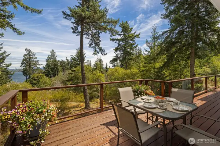 A generously sized wrap-around deck with glass-panel railings offers an al fresco dining area set against a lush backdrop of towering Pacific Northwest conifers, perfect for morning coffee or evening gatherings. Propane-plumbed for gas BBQ grill complete this effortless outdoor living space. A generously sized wrap-around deck with glass-panel railings offers an al fresco dining area set against a lush backdrop of towering Pacific Northwest conifers, perfect for morning coffee or evening gatherings. Propane-plumbed for gas BBQ grill complete this effortless outdoor living space.