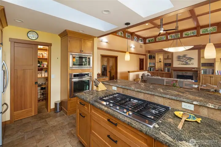 A professional-grade stainless gas cooktop anchors the granite island, positioned directly opposite double wall ovens and refrigerator for a highly functional cooking triangle. A discreet walk-in pantry door opens to reveal generous storage, while sightlines through to the great room maintain an open, connected feel. A professional-grade stainless gas cooktop anchors the granite island, positioned directly opposite double wall ovens and refrigerator for a highly functional cooking triangle. A discreet walk-in pantry door opens to reveal generous storage, while sightlines through to the great room maintain an open, connected feel.