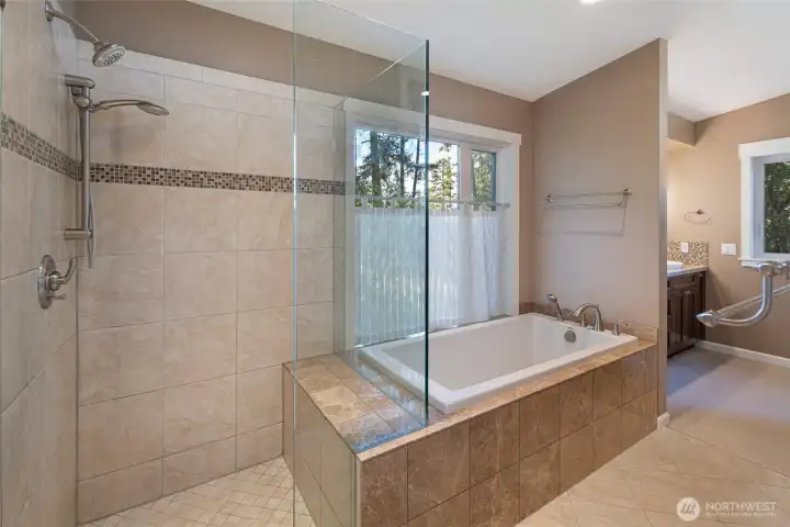 A deep drop-in soaking tub is elegantly framed by a tiled surround and positioned beside a private window overlooking lush evergreens, while a frameless glass walk-in shower with dual rain heads offers a true spa experience. The thoughtful layout and premium finishes make this bathroom an exceptional daily sanctuary. A deep drop-in soaking tub is elegantly framed by a tiled surround and positioned beside a private window overlooking lush evergreens, while a frameless glass walk-in shower with dual rain heads offers a true spa experience. The thoughtful layout and premium finishes make this bathroom an exceptional daily sanctuary.