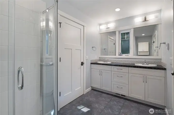 his beautiful secondary jack-and-jill full bath showcases white shaker cabinetry, a dark granite double-sink vanity, and a glass-enclosed tile shower, all unified by crisp grey porcelain tile flooring. The clean, contemporary design offers a fresh and functional space for family or guests. his beautiful secondary jack-and-jill full bath showcases white shaker cabinetry, a dark granite double-sink vanity, and a glass-enclosed tile shower, all unified by crisp grey porcelain tile flooring. The clean, contemporary design offers a fresh and functional space for family or guests.