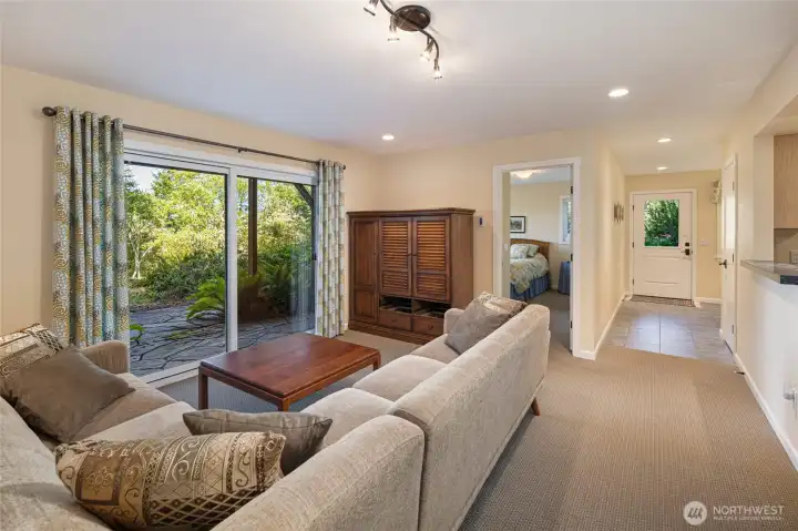 A cozy sitting room in the first floor guest quarters create an intimate gathering space. Sliding glass doors frame breathtaking views of the stone terrace and tranquil wooded surroundings. A cozy sitting room in the first floor guest quarters create an intimate gathering space. Sliding glass doors frame breathtaking views of the stone terrace and tranquil wooded surroundings.