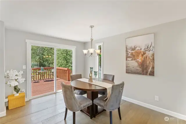 Dining space connects easily to sliding doors that lead out to a large back deck, stained glass window balances out the space and ties in the window next to front door