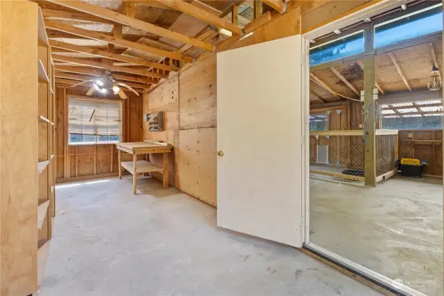 Tack room with shelving, work bench and 2 windows.