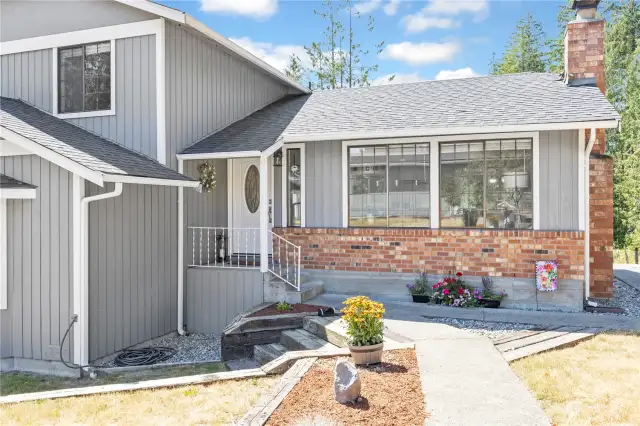 Walkway from detached garage lead to the covered front patio, or follow cement pathway around home to large back deck.