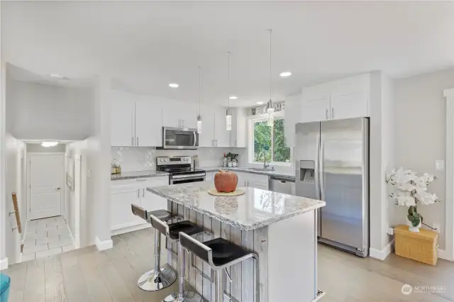 Kitchen island has seating for up to 3 with wood accents details