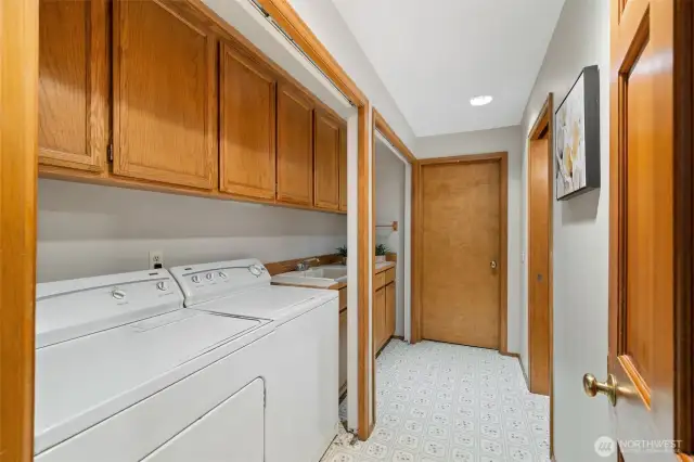 Huge laundry room with sink and extensive cabinetry.