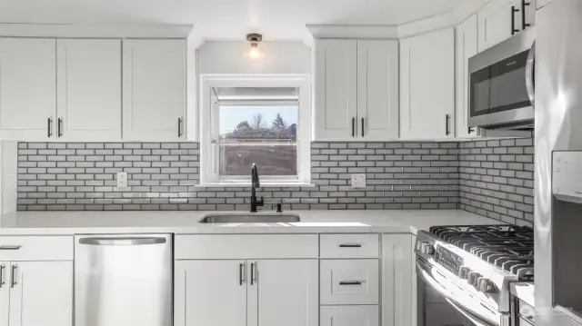 The window above the sink offers a charming view of the backyard, bringing in natural light and a refreshing outdoor connection.