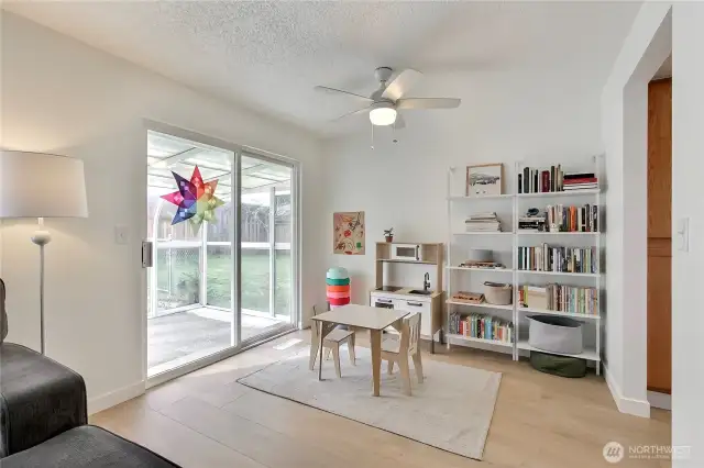 Flexible bonus space just off the main living area, perfect for a playroom, reading nook, or home office. Wide-plank laminate floors continue throughout, and a ceiling fan adds comfort year-round. Large sliding glass doors open to the covered sunroom and backyard, bringing in tons of natural light and expanding your indoor-outdoor living options.
