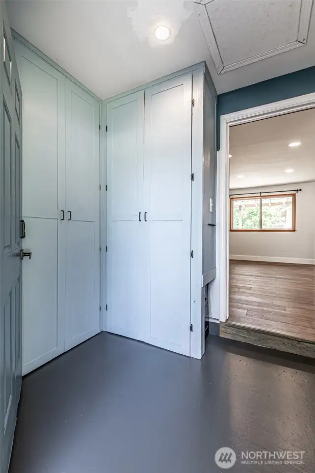 View into mud room from exterior entry door showing additional cabinets and into family room.