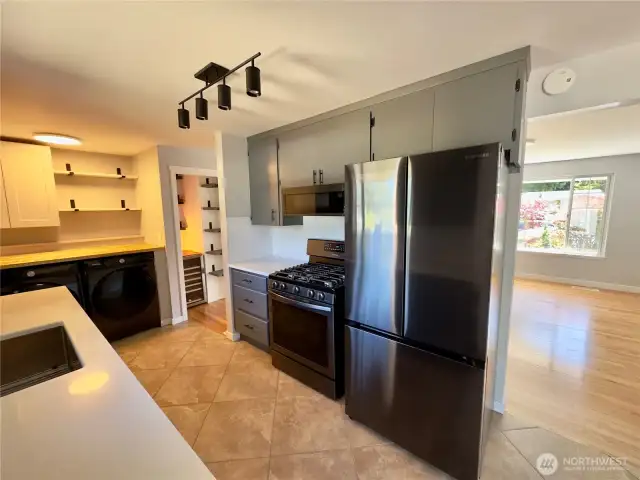 Black stainless steel appliances throughout kitchen and laundry