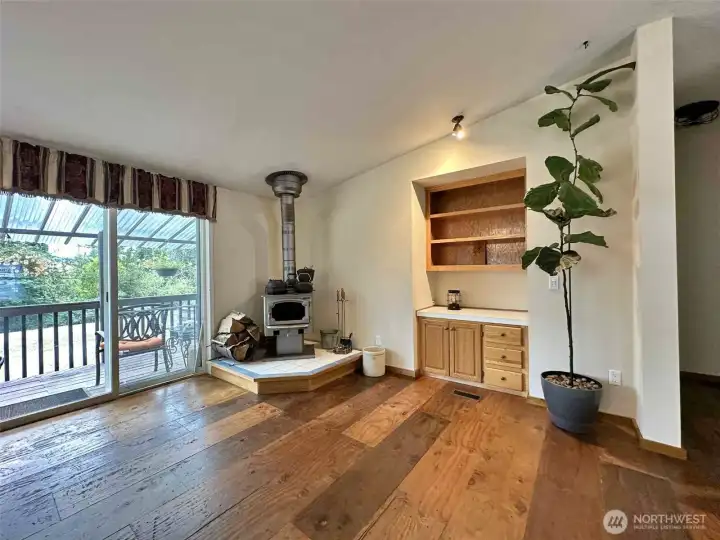 Dining area with wood floors. The wood stove heats the entire home.