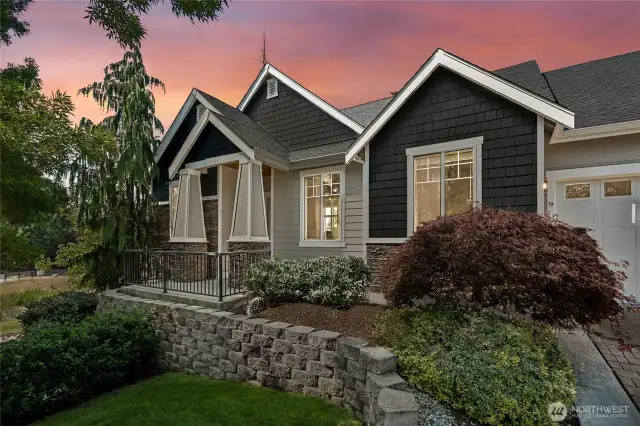 Charming front entry facade with detailed trim and elegant iron porch railing.
