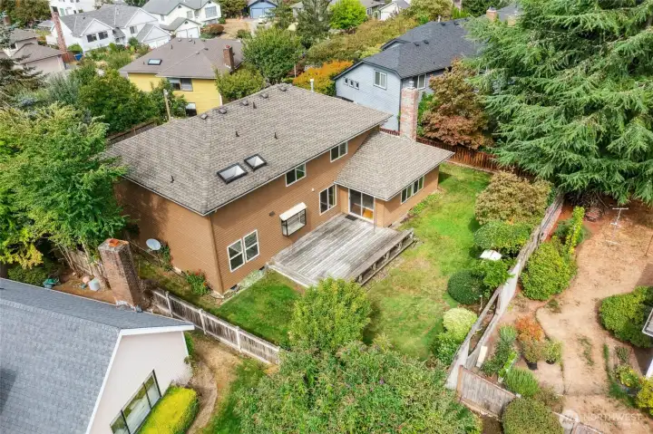 Large partially fenced rear yard with mature landscaping for outdoor enjoyment!