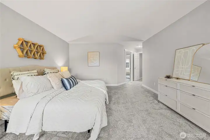 Primary bedroom that easily fits a King sized bed plus dresser and more!