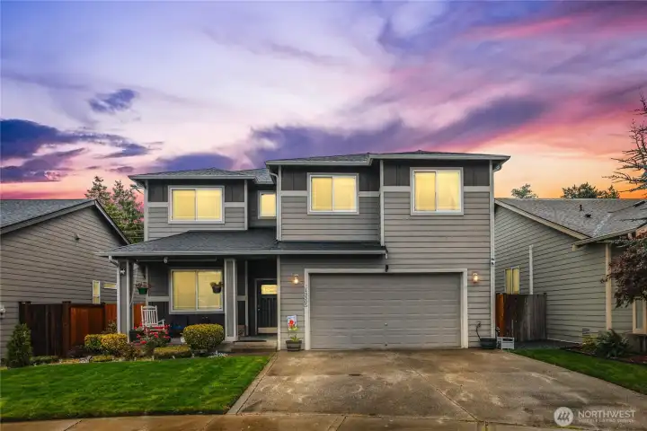 Twilight exterior photo - spacious driveway and low-maintenance front yard.
