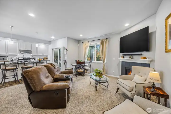 Bright and spacious living room featuring carpet, recessed lighting, and a gas fireplace